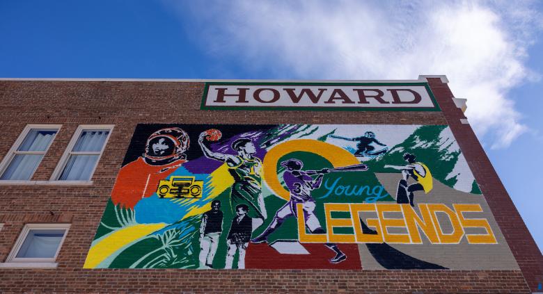 A colorful mural on a brick wall that reads "Young legends" featuring portraits of a baseball player, basketball players and more.